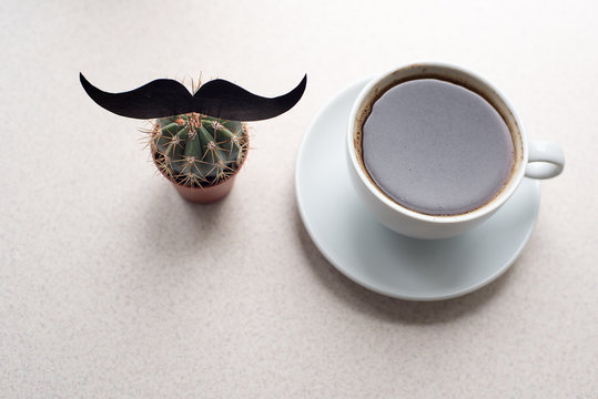 white cup with coffee and flowerpot cactus with print mustache on a white background. Happy fathers day concept. empty copy space for your text. top view