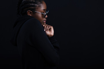 Posing african woman sitting with dark skin wearing round sunglasses