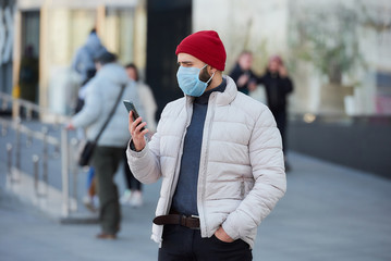 A caucasian man wearing a medical face mask to avoid the spread coronavirus (COVID-19). A guy with...