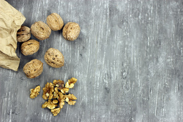 Walnut kernels and whole nuts on an old gray table. Seletive focus, copy space