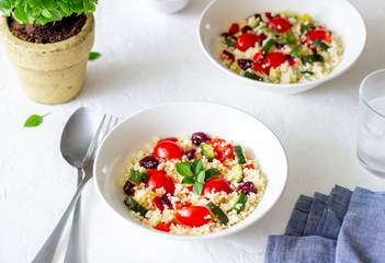 Couscous salad with tomatoes, peppers, courgettes and cranberries. Vegetarian food. Diet. Healthy eating.