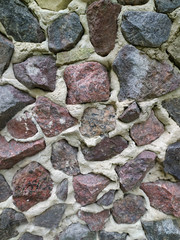Gray, brown, black stone wall background, granite mosaic stonewall rubble facade closeup texture