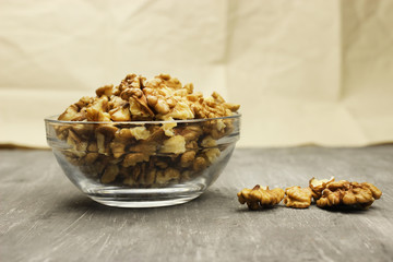 walnut kernels in a bowl on a gray background