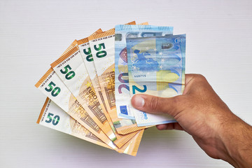 hand with 50 and 20 euro bills