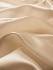 Beautiful smooth elegant wavy beige / light brown satin silk luxury cloth fabric texture, abstract background design. Copy space.