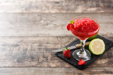 Strawberry margarita cocktail in glass on wooden table. Copy space	