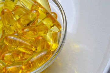 Fish oil capsules on a glass plate. A lot of vitamin omega 3. Close-up.