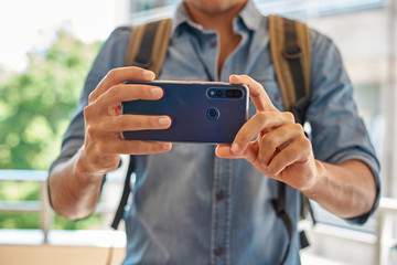 person taking pictures with his blue mobile