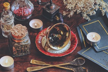 Vintage teacup laying on it's side on a wiccan witch altar for reading tea leaves as a method of...