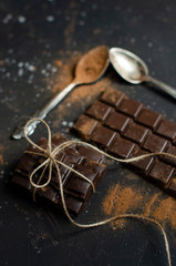 pieces of dark chocolate tied with string and sprinkled with cocoa powder with dried oranges