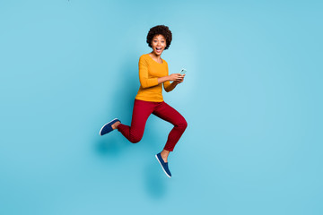 Fototapeta na wymiar Full length body size view of her she nice attractive lovely glad cheerful cheery wavy-haired girl jumping running fast using cell smm isolated on bright vivid shine vibrant blue color background