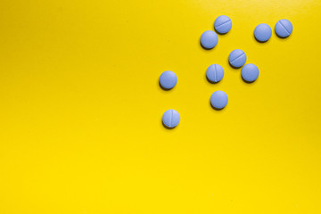 Close-Up Of Blue Pills Against Yellow Background. Concept isolated.