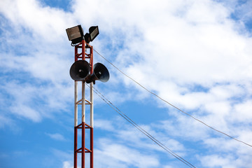 Speaker on high steel tower for Warning and spread the news with sport light in and clear sky