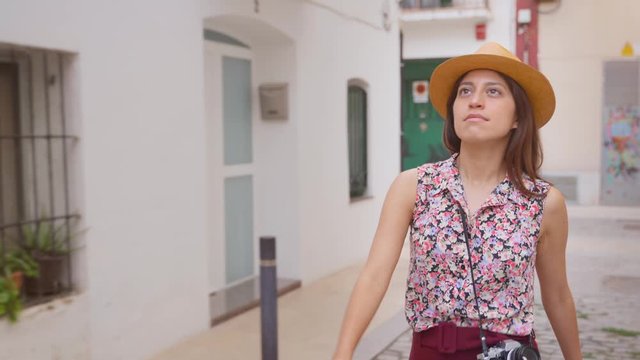 Young female tourist walking in the white streets of a mediterranean country such as Spain, Portugal or Greece