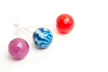 Piruletas de colores sobre un fondo liso y aislado blanco. Vista superior y de cerca. Copy space