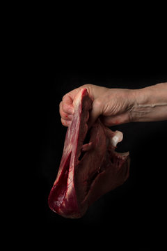 Raw Beef Heart In Women Hand On A Black  Background