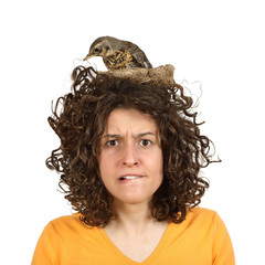 Young girl with a nest and a bird on her head