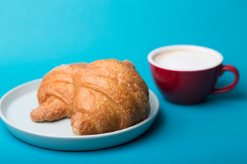 red cup with croissant on a blue background