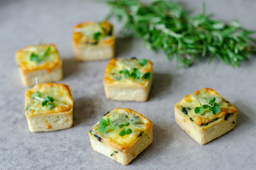Savory tart shells filled with mixed peppers, artichoke, parmesan, cream, and egg