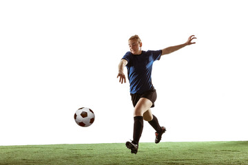 Naklejka premium Young female soccer or football player with long hair in sportwear kicking ball for the goal, training on white studio background. Concept of healthy lifestyle, professional sport, motion, movement.