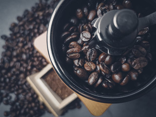 Roasted coffee beans in a coffee grinder on dark background