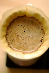 Freshly brewed coffee in a funnel with froth
