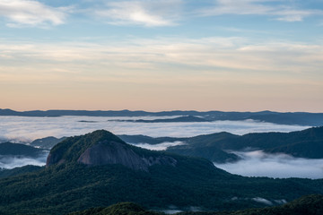 Fototapeta na wymiar Scenic sunrise view from the Blue Ridge Parkway of Looking Glass Rock, a popular climbing and hiking destination attraction in Pisgah Forest of Brevard, near Asheville, North Carolina