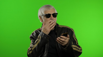 Elderly stylish caucasian grandfather man using smartphone for online shopping