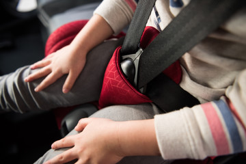 A close up of a child infants seat belt tightly fixed in place, for security and protection of toddlers travelling in a car. Child protection in automobiles and baby booster seats.