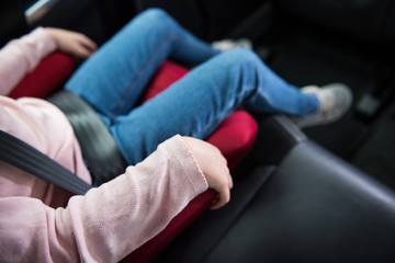 A close up of a child infants hand holding tightly on a seat belt tightly fixed in place, for security and protection of toddlers travelling in a car. Child protection in automobiles