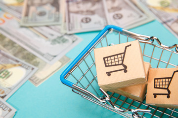 Money banknotes dollar and shopping basket with boxes on blue background.Easy shopping with finger...