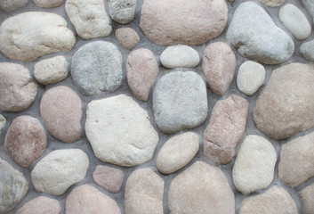 Wall round stone rock texture background. Big stones on the roadway.