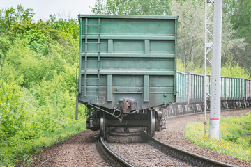 Fototapeta na wymiar Freight train moves by the summer forest.