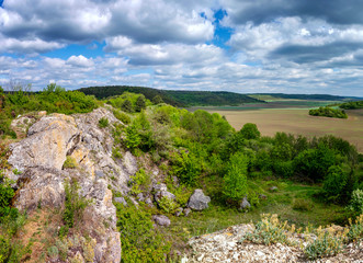 Landscape with stony hills and blue sky with beautiful clouds. Ukraine, Medobory Nature Reserve