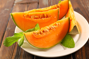 melon sliced with mint leaf on plate