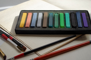 Naklejka premium crayons of art pastels on a table with tassels