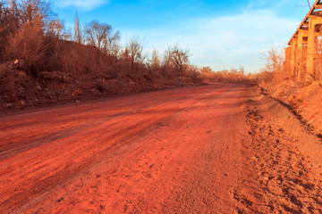 Red dirt road polluted with iron ore near iron ore quarry in Kryvyi Rih, Ukraine