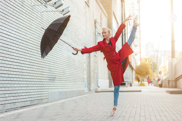 ballerina jumping and dancing with an umbrella in the autumn