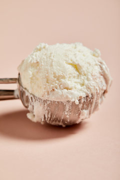 Close up view of fresh tasty ice cream ball in scoop on pink background
