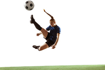 Fototapeta na wymiar Young female soccer or football player with long hair kicking ball for the goal in flight, jumping high on white studio background. Concept of healthy lifestyle, professional sport, motion, movement.