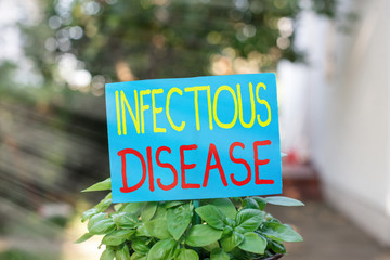 Writing note showing Infectious Disease. Business concept for caused by pathogenic microorganism,...
