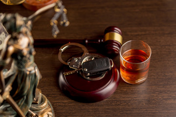 Whiskey with car keys and handcuffs. Concept for drinking and driving