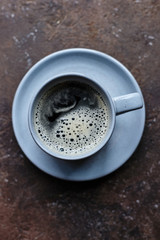 gray cup of coffee on a dish and brown background