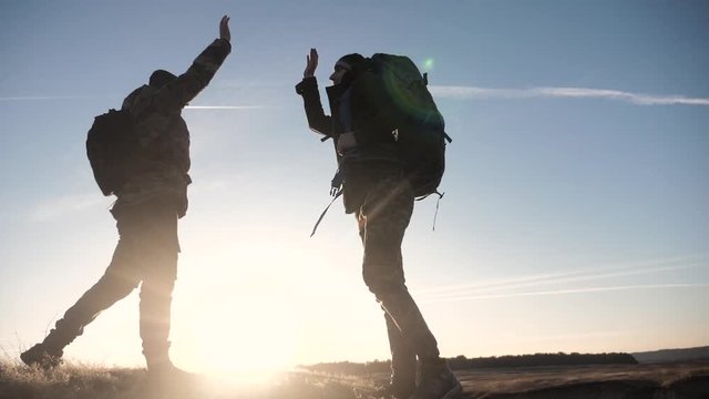 concept victory teamwork achievement goal slow motion video business concept. two tourists meet on top of a mountain with backpacks shake hands lifestyle . climbers meet on top of a mountain teamwork