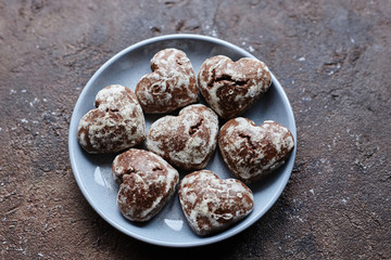 small heart-shaped chocolate gingerbread cookies in a round gray plate