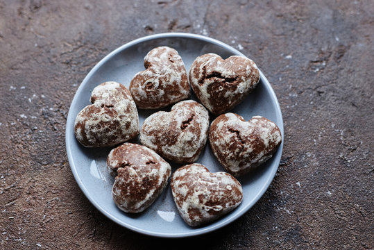 small heart-shaped chocolate gingerbread cookies in a round gray plate