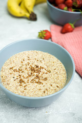Flax porridge with banana and strawberries on a light background. Healthy breakfast