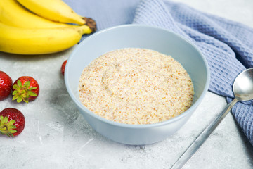 Flax porridge with banana and strawberries on a light background. Healthy breakfast