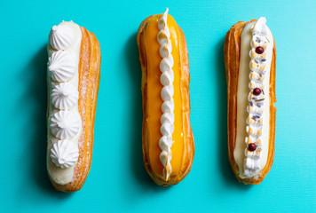 three delicious eclairs on a green and blue background 