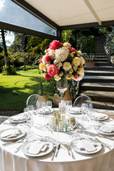 in backyard of villa in Tuscany there is banquet wooden table decorated with cotton and eucalyptus compositions